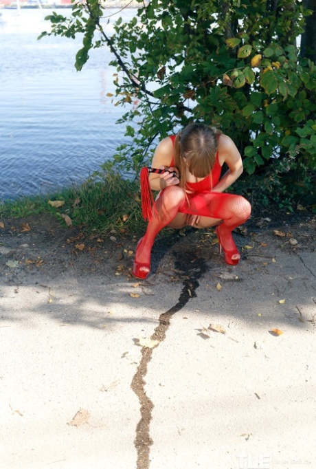 Pretty Natalie Russ in pigtails outside toying pussy in red sheer pantyhose 53882384