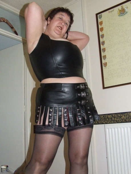 Mature amateur Kinky Carol removes leather wear to get naked in stockings 56505423