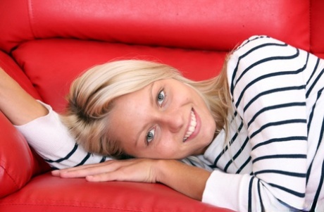 Barely legal blonde strips naked to show her tan lined body on a red couch 27628127