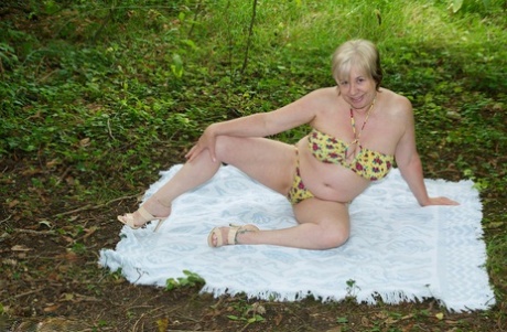 Thick mature woman Speedybee strips naked on a blanket down by the river 39347868
