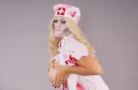 Old blonde amateur Savana removes a nurse uniform during a cosplay scene