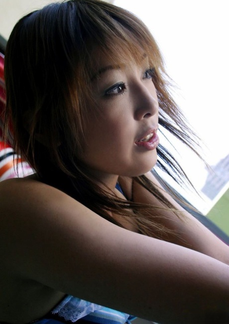 Beautiful Japanese girl Megumi Yoshioka models a bra and panty set on a bed 99951819
