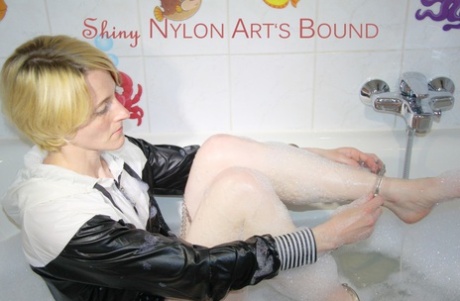 Caucasian girl dons cuffs while bathing by herself in nylon clothing 79162743