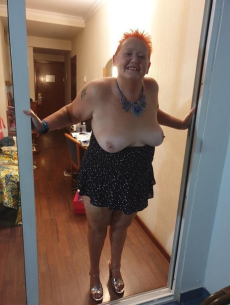 Fat nan with short red hair presses her big boobs and butt up against glass 42358050