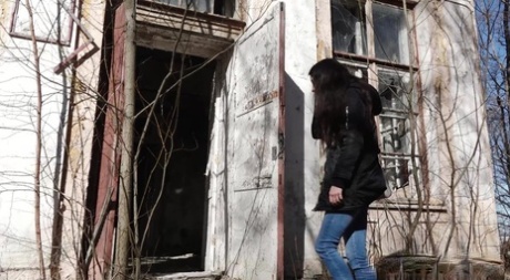 Clothed girl Katya pulls down her blue jeans to pee by an abandoned building 76509515