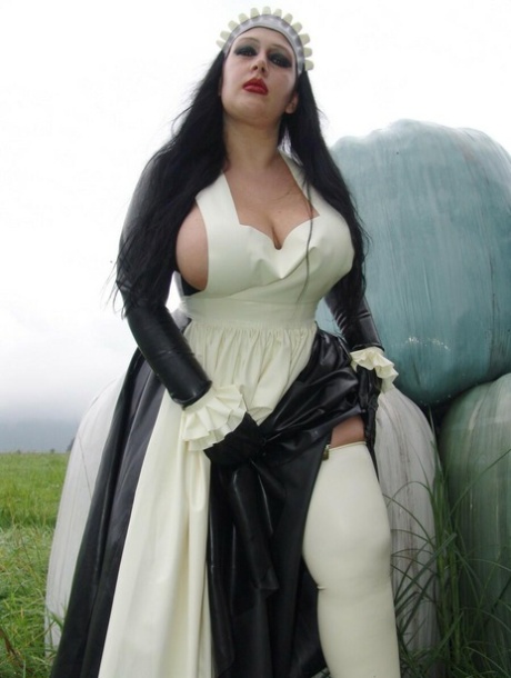 Goth woman Lady Angelina does her laundry outdoors in a tub in latex clothing 46816296